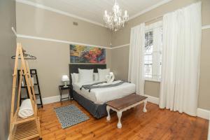 a bedroom with a bed and a ladder and a painting at Crown Oak in Gqeberha