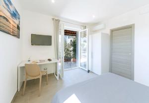 a bedroom with a bed and a desk and a television at Villetta Mami in Ischia