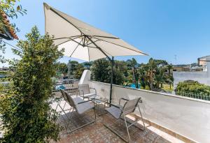 a couple of chairs and an umbrella on a roof at Villetta Mami in Ischia