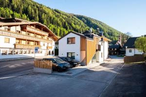 a car parked in a parking lot next to some buildings at AurAlpin Apartments in Cadipietra