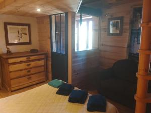 a bedroom with a bed with two blue pillows on it at La chambre Nature chez les garçons in Saint-Paul-sur-Yenne