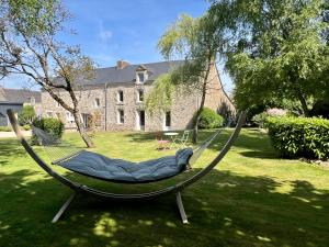a hammock in a yard in front of a house at L'Escale d'Armorique 2 in Languidic