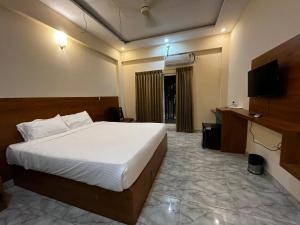 a hotel room with a bed and a television at Emporia comforts in Devanhalli