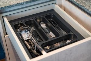 a sink with dishes and utensils in a drawer at AurAlpin Apartments in Cadipietra