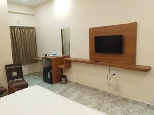 a hotel room with a tv on the wall at Emporia comforts in Devanhalli