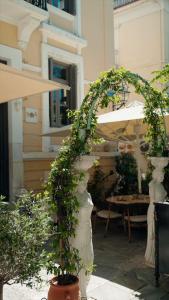 an outdoor patio with an arch and potted plants at ROH Suites in Athens