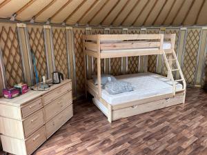 a bedroom with a bunk bed and two dressers in a yurt at Fermily Lodges in Perrières