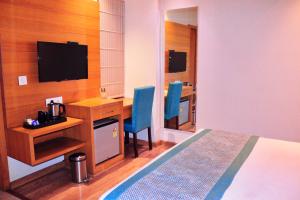 a hotel room with a desk and a bed and a desk and a television at Hotel Landmark Near Golden Temple in Amritsar