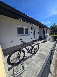 a bike is parked on a balcony of a house at Tiny House Ciciban - self check in and check out in Otočac