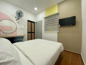 a bedroom with a bed and a desk and a mirror at Moon Hotel BRINCHANG Town in Brinchang