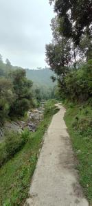 a dirt road with trees on the side of a hill at Fursat Exclusive Solitude in Rāmgarh