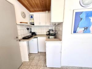 a kitchen with white cabinets and a sink at Nádaspart Vendégház in Zánka