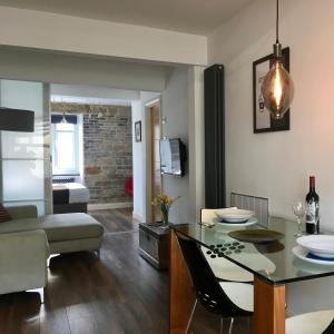 a living room with a table and a dining room at Over Under Cottage in Holmfirth
