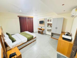 a bedroom with a bed and a television in it at Hotel Sun Park Vadodara in Vadodara