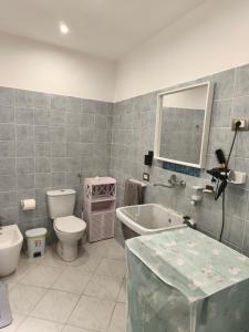 a bathroom with a toilet and a tub and a sink at Cibali rooms in Catania +80 photos