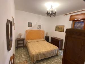 a small bedroom with a bed and a chandelier at Happy Rock in Formia