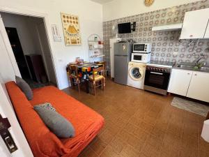 a living room with an orange couch in a kitchen at Happy Rock in Formia +10 photos