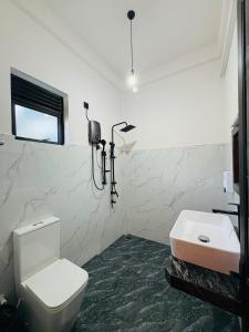 a bathroom with a white toilet and a sink at The Green View Yala in Tissamaharama +67 photos
