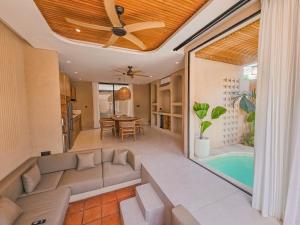 a living room with a couch and a ceiling fan at Antonella De Rosa Villas in Nusa Dua +22 photos