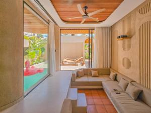 a living room with a couch and a ceiling fan at Antonella De Rosa Villas in Nusa Dua
