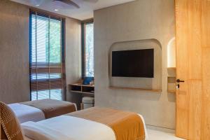 a hotel room with two beds and a flat screen tv at Antonella De Rosa Villas in Nusa Dua