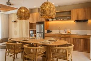 a kitchen and dining room with a wooden table and chairs at Antonella De Rosa Villas in Nusa Dua