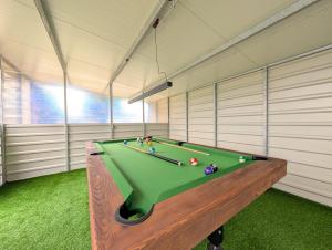 a room with a pool table in a room at Domki Bryza Kępy ze strefą sportową oraz miejscem do grillowania i rowerami GRATIS in Wydmina