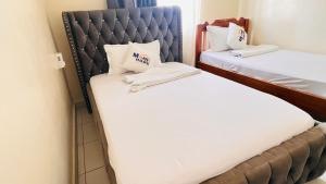 two beds in a hotel room with towels at 3 bedroom house buxton in Mombasa +16 photos