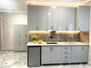 a kitchen with white cabinets and a sink at River Light-Guest House in Alaverdi