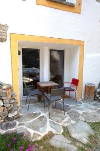 a patio with chairs and a table on a stone patio at Casa Piazzo in Brusio +7 photos