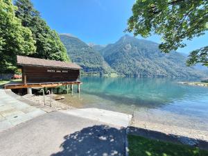a building next to a body of water with mountains at Casa Piazzo in Brusio