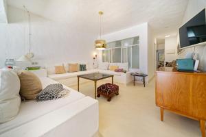 a living room with a white couch and a table at Sardina Ocean Front Apartment in Gáldar
