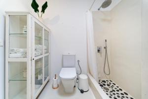 a white bathroom with a toilet and a shower at Sardina Ocean Front Apartment in Gáldar +22 photos