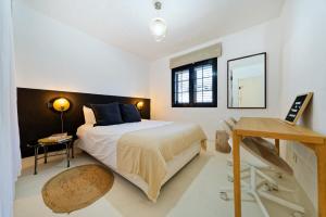a bedroom with a bed and a table and a mirror at Sardina Ocean Front Apartment in Gáldar