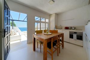 a kitchen with a wooden table and a large window at Sardina Ocean Front Apartment in Gáldar