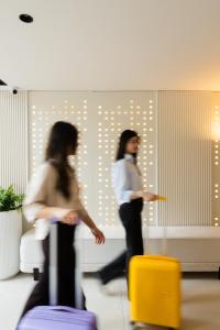 two women standing in a room with luggage at Palladion Boutique Hotel in Argos