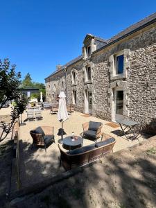 a patio with a table and chairs and a building at L'Escale d'Armorique 2 in Languidic