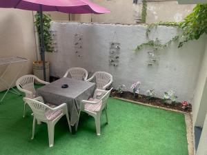 a table with chairs and an umbrella on a patio at Secret Garden Mostar in Mostar