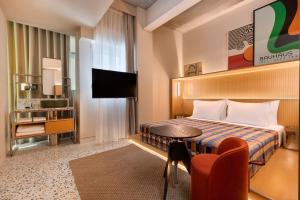 a hotel room with a bed and a table and a tv at Dizengoff 99 by Isrotel Design in Tel Aviv