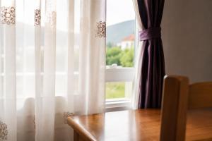 a room with a table and a window with curtains at Hotel Klajdi in Peshkopi