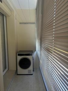 a washer and dryer in a room with blinds at Appartement Montalieu in Montalieu-Vercieu +2 photos