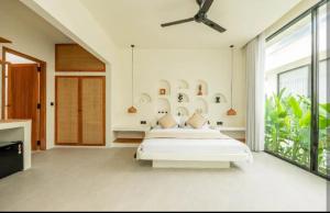 a bedroom with a bed and a ceiling fan at Julie House Lombok in Ekas +26 photos