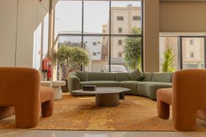 a living room with a couch and a table and chairs at LEGooT HOTEL in Khamis Mushayt