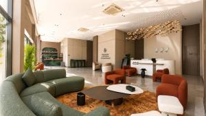 a lobby with a green couch and orange chairs at LEGooT HOTEL in Khamis Mushayt