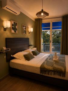 a bedroom with a large bed and a window at Hotel Cayrons Vence & St Paul de Vence in Vence +60 photos