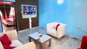 a living room with two chairs and a tv at Awka Dawn Two Bed in Akwa