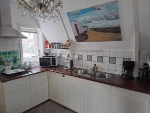 a kitchen with a sink and a microwave at Het Speijerhuis in Harlingen