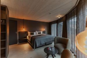 a bedroom with a bed and a couch and a chair at Roggenstock Lodge in Oberiberg +123 photos