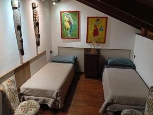 two beds in a room with paintings on the wall at Monferrato Inn in Rivarone