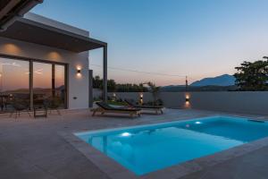 a villa with a swimming pool at dusk at Villa Esperia in Áyios Síllas